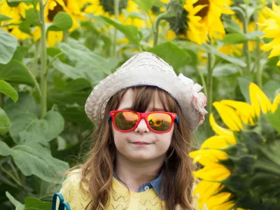 A child in a field of sunflowers - photo by Charlotte Coneybeer